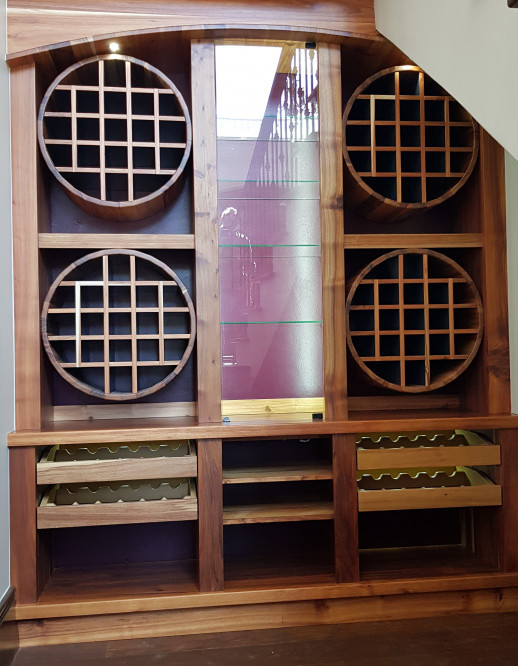 Wine cellar with round shelving units and drawers with internal lighting 