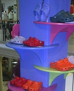 Curved shelves on blue column to display shoess